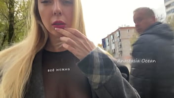 A nymph shows her mammories while walking in public in the city